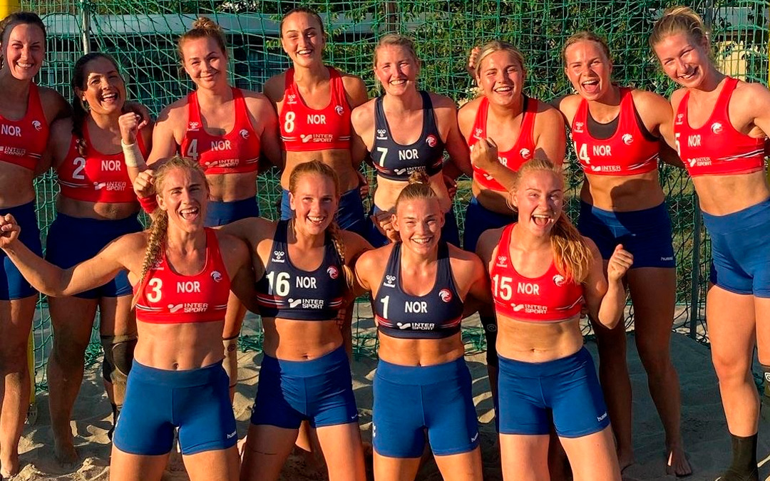 Gruppenfoto der norwegischen Beachhandballerinnen. Alle tragen blaue Shorts. 