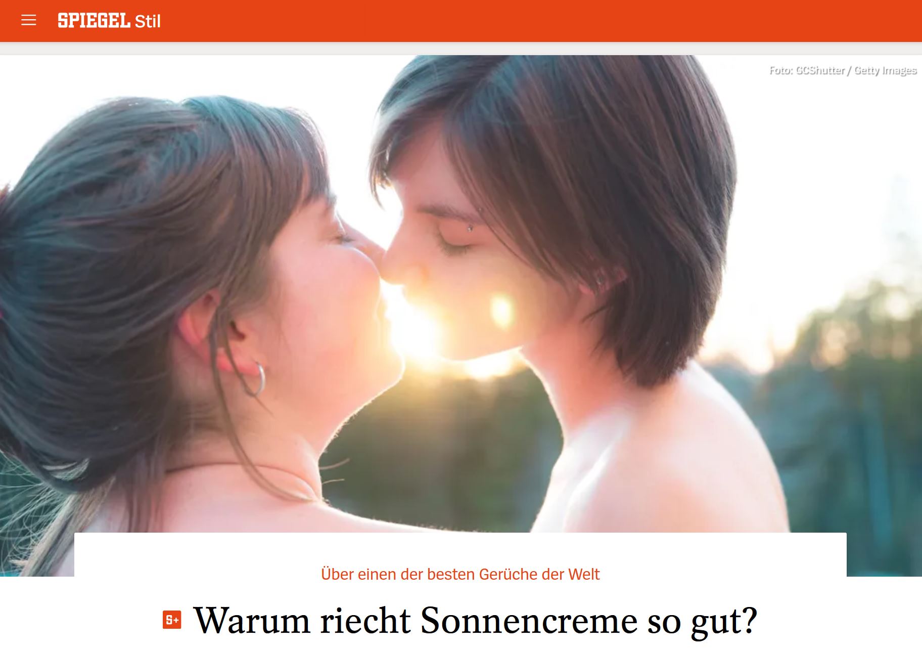 Zwei Frauen küssen sich, zwischen ihren Mündern blendet die untergehende Sonne