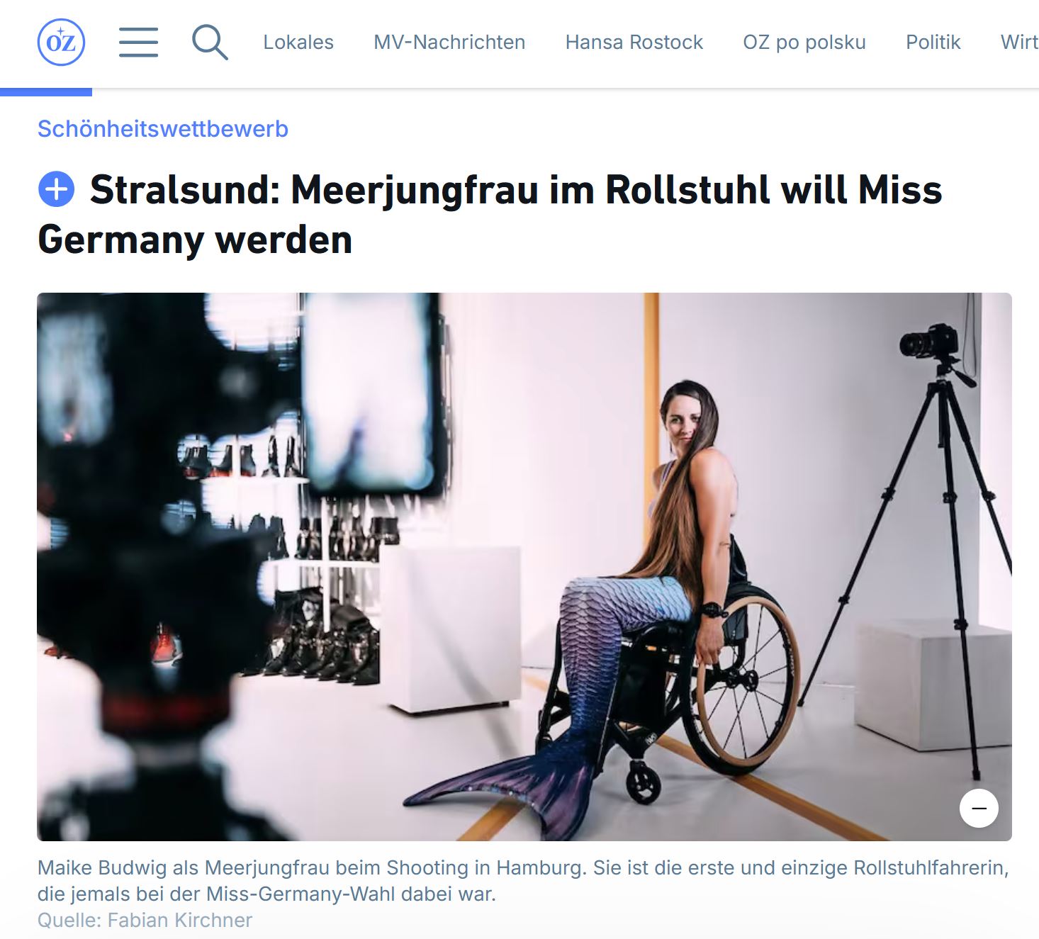 Fotostudio: Junge Frau mit langen Haaren sitzt mit Meerjungfrauen-Flossen im Rollstuhl 